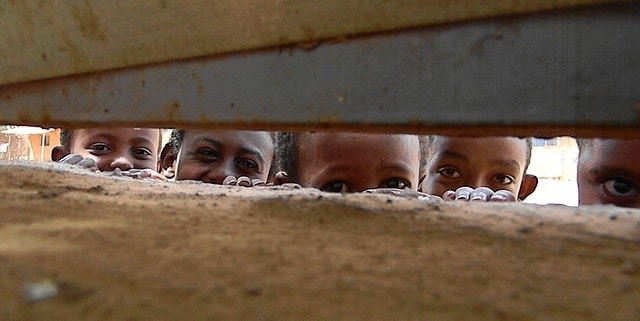 3 ילדים אתיופיים מסתכלים מבעד לחרך