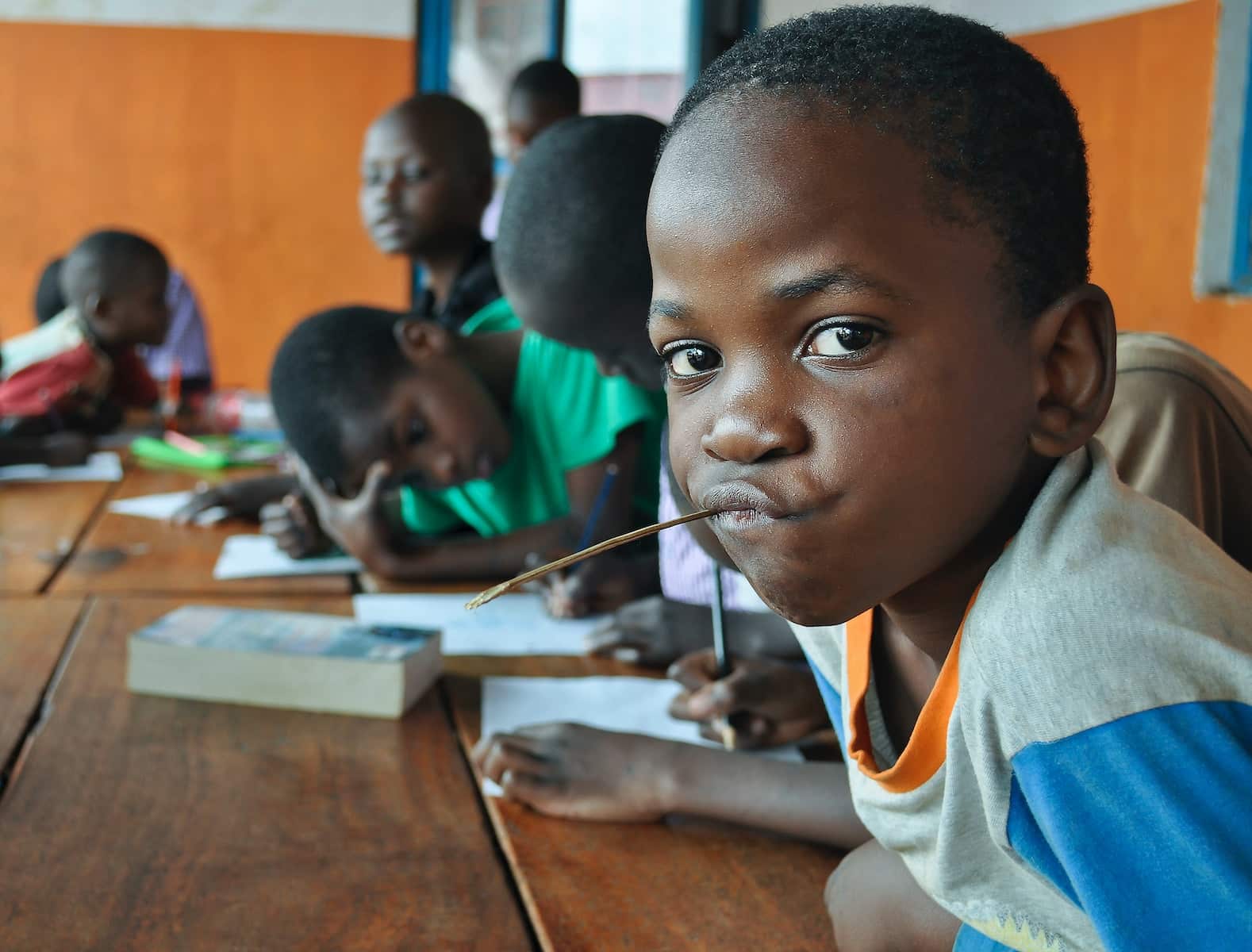 קבוצה של ילדים צעירים יושבים ליד שולחן הלימודים באפריקה